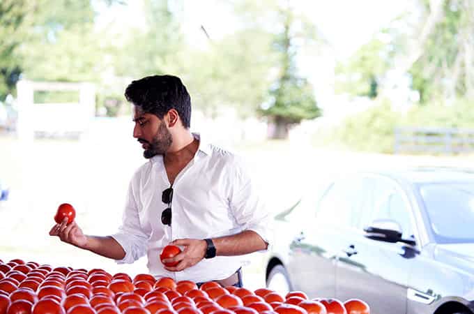 Aakash Trivedi selects tomatoes alongside his Jaguar XF.